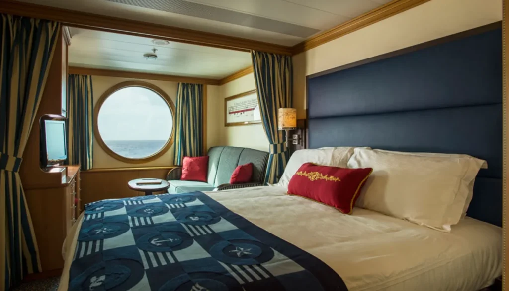 Cabine interna do cruzeiro Disney Magic com cama de casal e sofá decorado com tema náutico.
