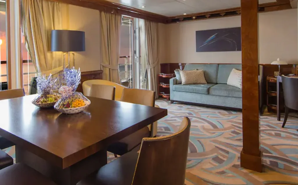 Suíte do Disney Magic com sala de estar, mesa de jantar e varanda.