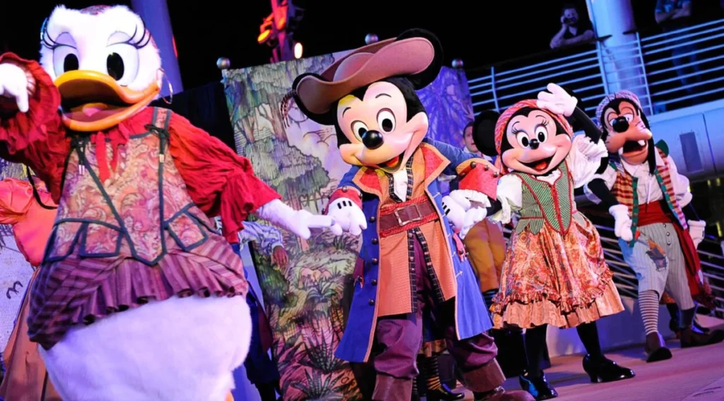 Personagens da Disney como Mickey, Minnie e Margarida vestidos de piratas em show a bordo de cruzeiro Disney.