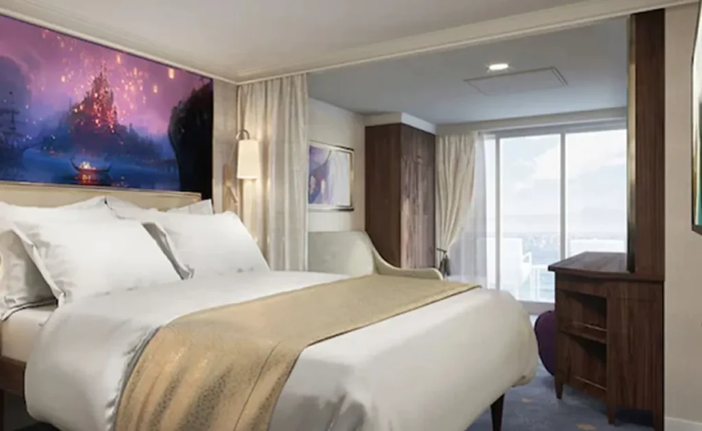 Cabine deluxe espaçosa com cama grande e varanda em navio Disney.