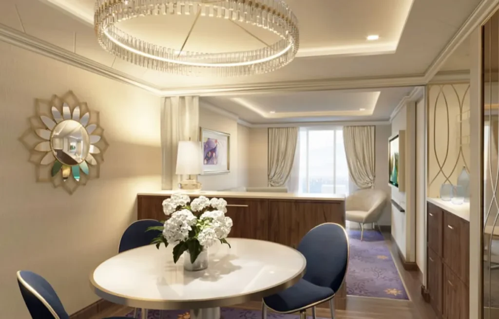 Suíte de luxo com sala de jantar e decoração sofisticada no Disney Wish.