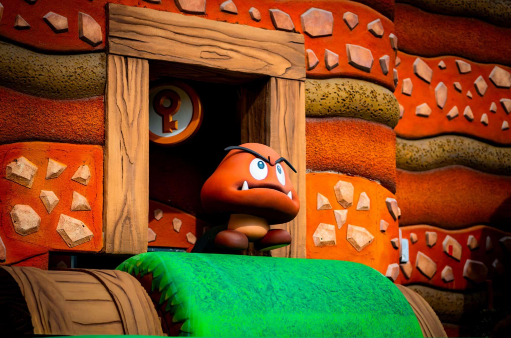 Personagem Goomba em cenário do Super Nintendo World.