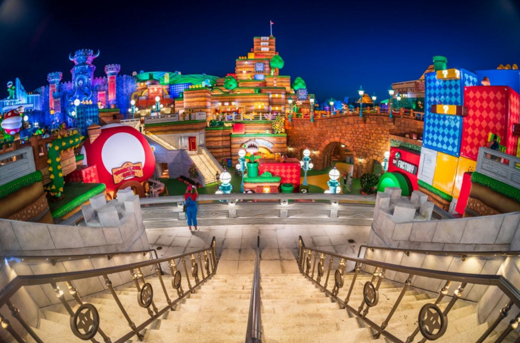 Vista noturna da entrada do Super Nintendo World com iluminação especial.