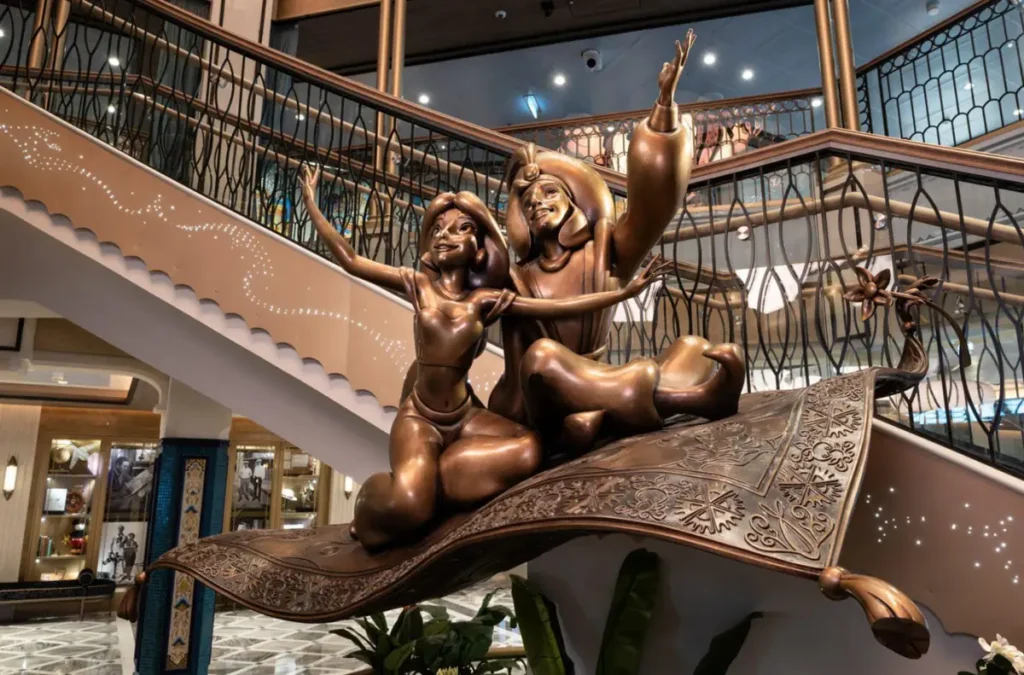 Estátua de Aladdin e Jasmine sobre o tapete mágico no Grand Hall do Disney Treasure da Disney Cruise Line