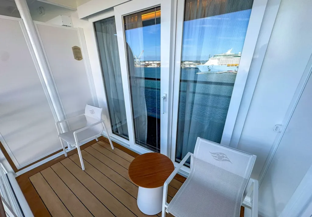 Varanda privativa da cabine Verandah do Disney Treasure com vista para o porto e oceano