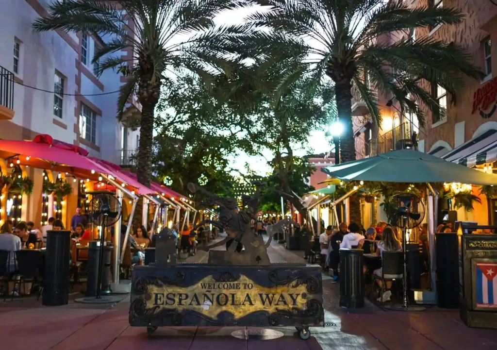A entrada da Española Way reúne palmeiras, restaurantes e iluminação noturna em um dos passeios mais charmosos da cidade.