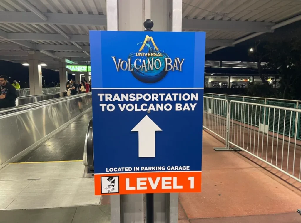 Placa Transportation to Volcano Bay dentro da garagem da Universal Orlando indicando o caminho para o transporte do parque aquático