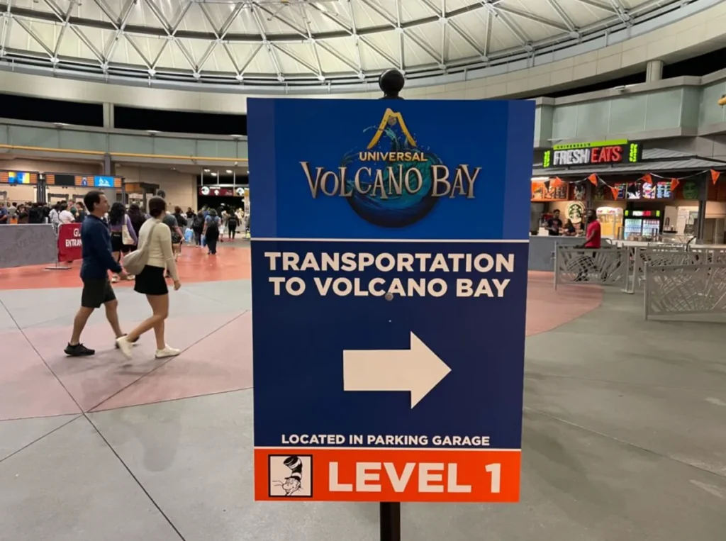 Sinalização Transportation to Volcano Bay na área interna da Universal Orlando indicando o trajeto do estacionamento até o transporte do parque