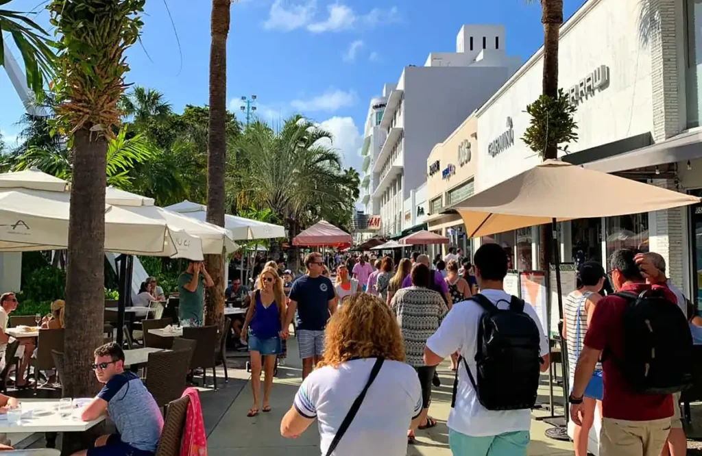 Turistas circulam entre restaurantes e lojas no calçadão da Lincoln Road, importante área comercial de Miami Beach.