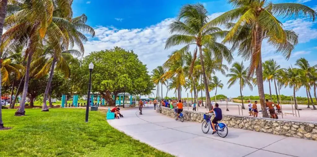 Ciclistas e pedestres aproveitam o calçadão arborizado do Lummus Park, junto à praia de South Beach.