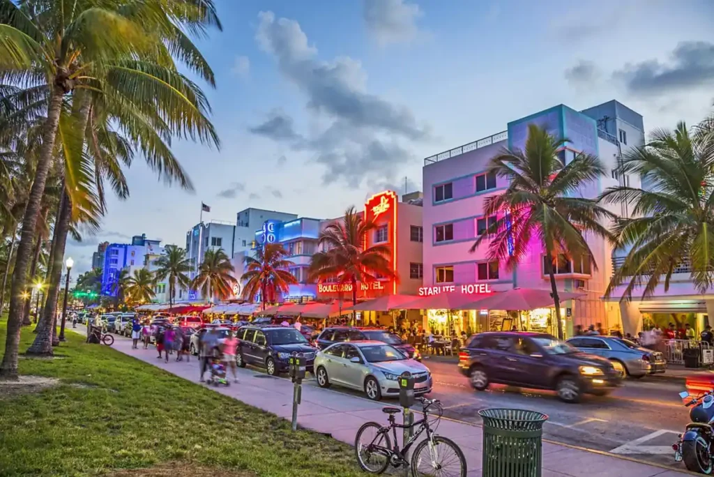 Hotéis e restaurantes da Ocean Drive iluminados por néon criam o cenário noturno clássico de Miami Beach.