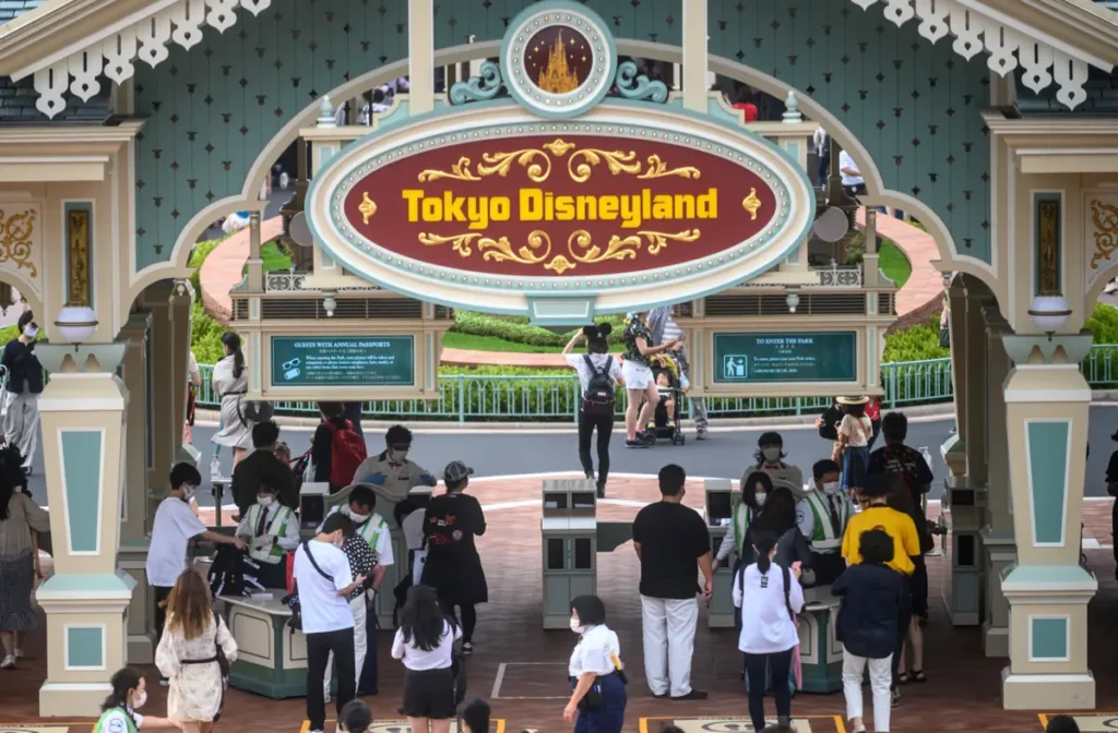 Placa da entrada da Tokyo Disneyland sobre as catracas de acesso ao parque.