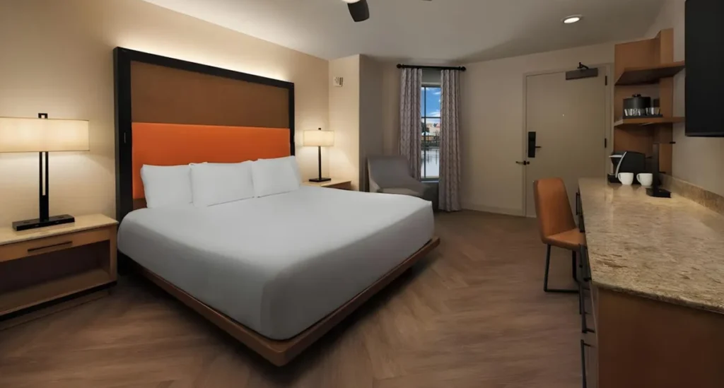 Quarto com cama king, bancada e decoração contemporânea no Disney’s Coronado Springs Resort.