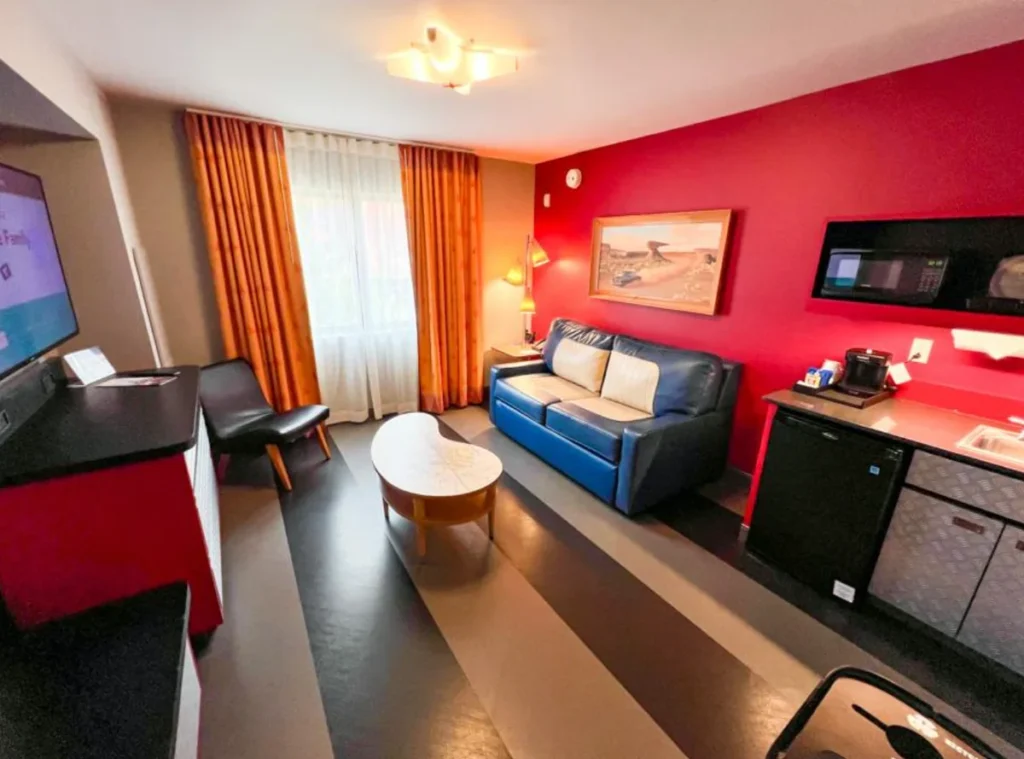 Sala da Cars Family Suite com sofá, copa e decoração inspirada no filme Carros.