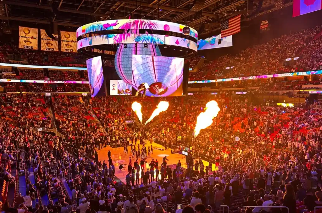 Jogos Miami Heat 2026-2027 - NBA - Kaseya Center recebe grande público para um jogo do Miami Heat, com apresentação de luzes, efeitos de fogo e atmosfera de NBA em Miami.