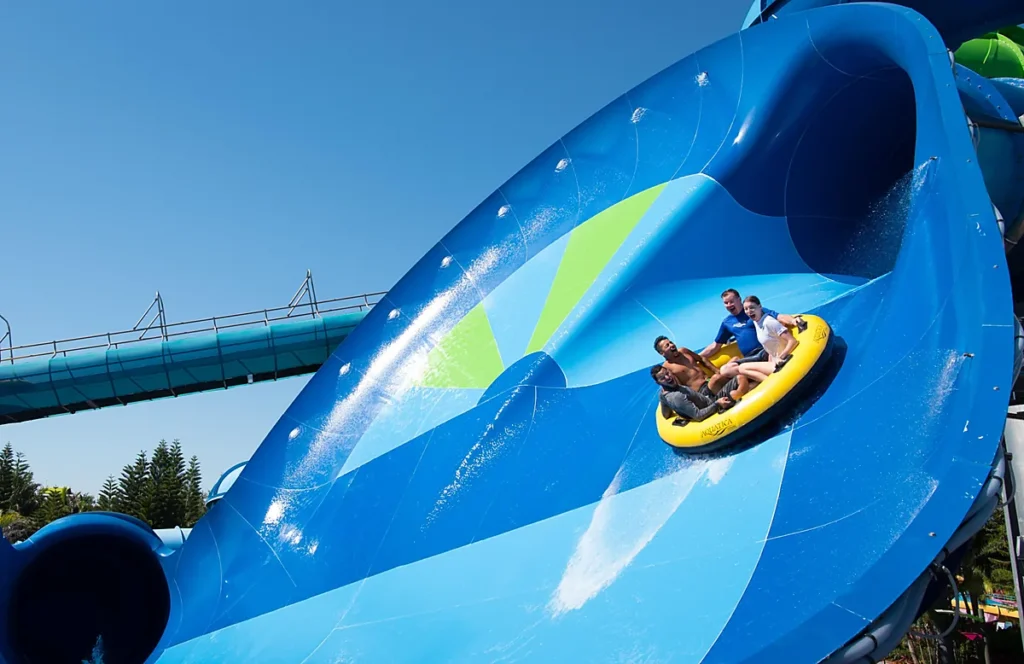 Melhores Atrações Aquatica Orlando - Diversão em grupo no Aquatica Orlando, com uma descida em boia coletiva por um enorme toboágua azul.