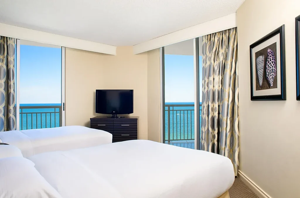 Quarto com duas camas e varanda de frente para o mar no DoubleTree Resort & Spa by Hilton Hotel Ocean Point, em Sunny Isles Beach, Miami.