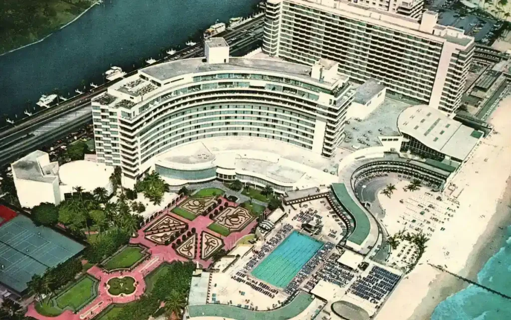 Imagem histórica do Fontainebleau Miami Beach mostrando sua arquitetura curva, piscina e área à beira-mar (1956)