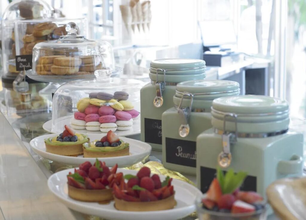 Seleção de doces e sobremesas do Grand Beach Hotel Miami Beach, incluindo macarons e tortas de frutas.