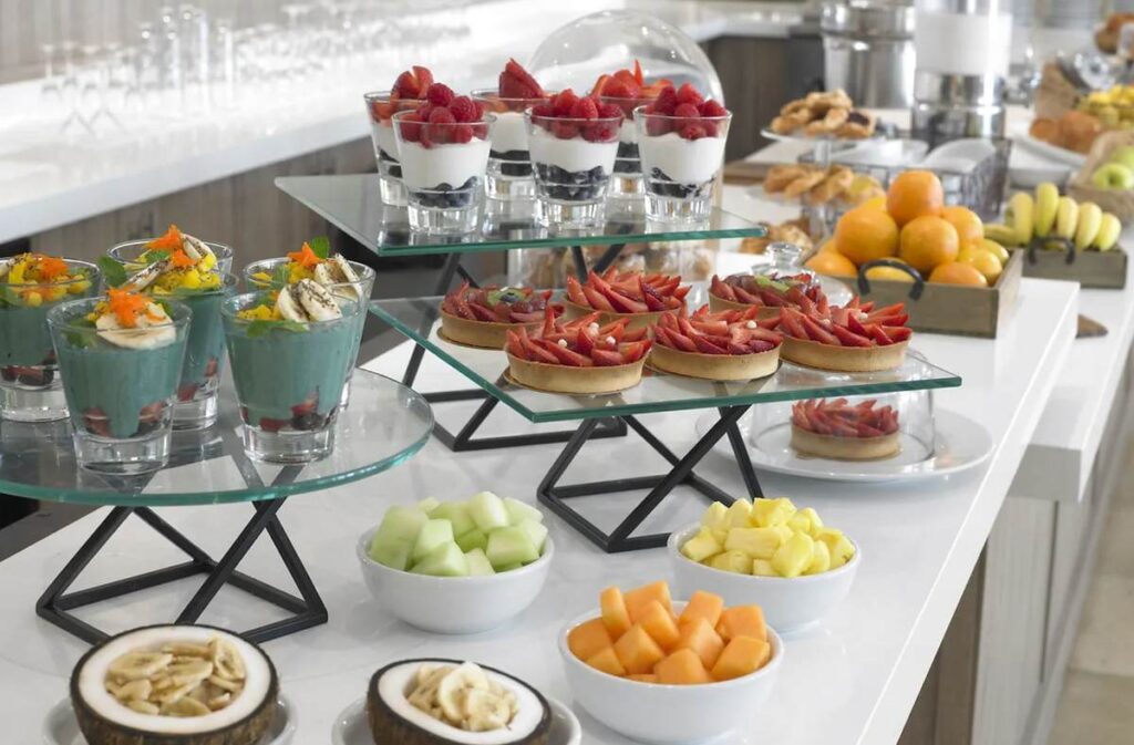 Buffet de café da manhã do Grand Beach Hotel Miami Beach com frutas frescas, iogurtes e doces.