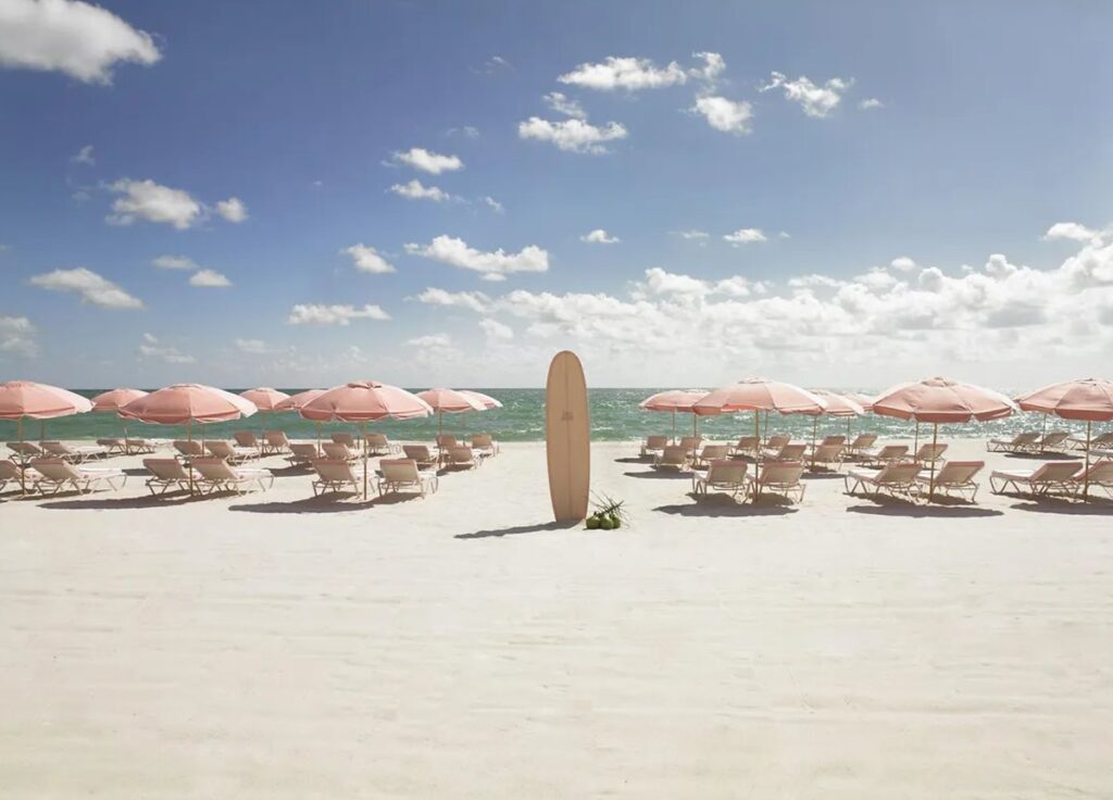 Praia do Grand Beach Hotel Miami Beach, com estrutura de espreguiçadeiras e guarda-sóis à beira-mar.