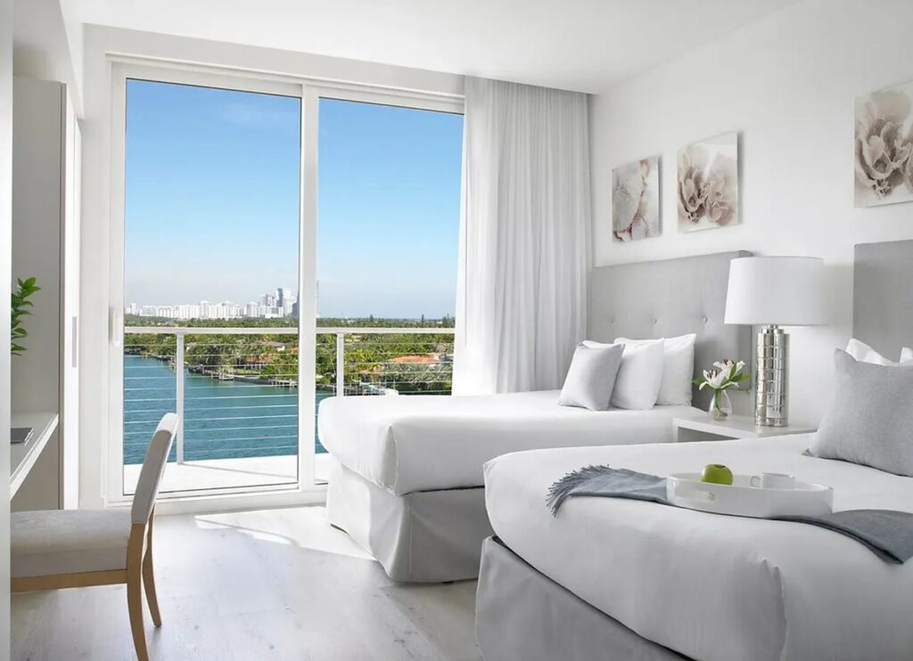 Quarto duplo do Grand Beach Hotel Miami Beach com varanda e vista para a região de Miami.