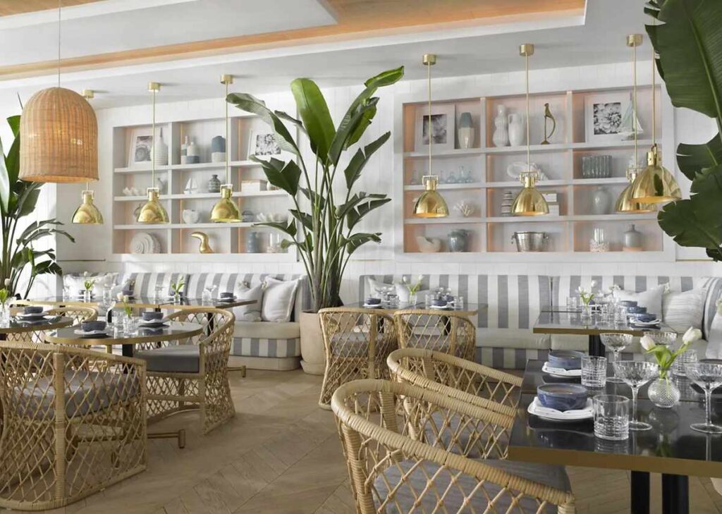 Restaurante do Grand Beach Hotel Miami Beach com decoração contemporânea, plantas tropicais e mobiliário em fibras naturais.