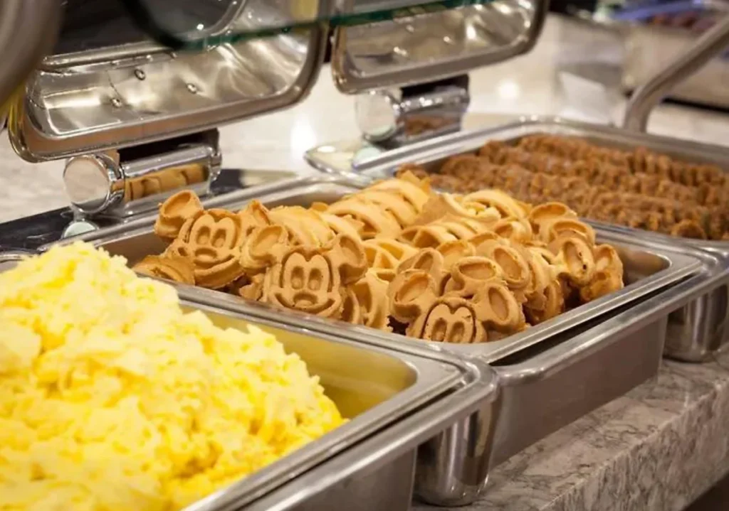 Café da manhã no Wyndham Garden Lake Buena Vista com waffles em formato do Mickey e opções quentes para começar o dia antes dos passeios.