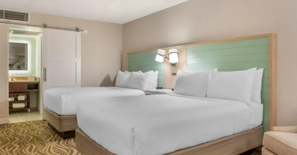 Acomodações do Wyndham Garden Lake Buena Vista com duas camas, decoração em tons suaves e ambiente confortável para descansar após os passeios em Orlando.