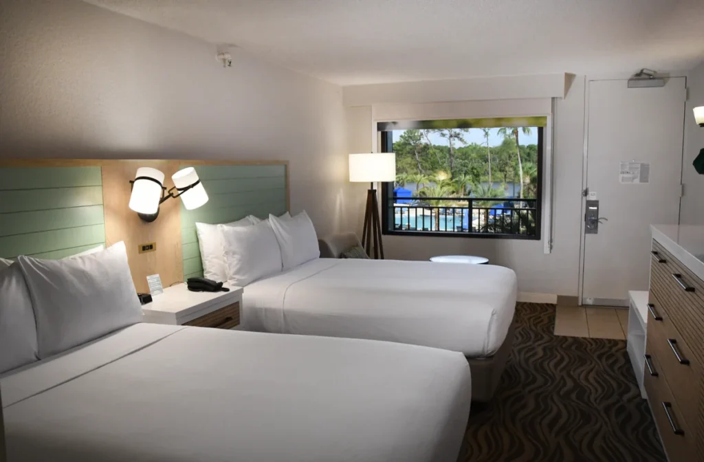 Quarto com duas camas e vista para a área da piscina do Wyndham Garden Lake Buena Vista, ideal para aproveitar a estadia em Orlando.