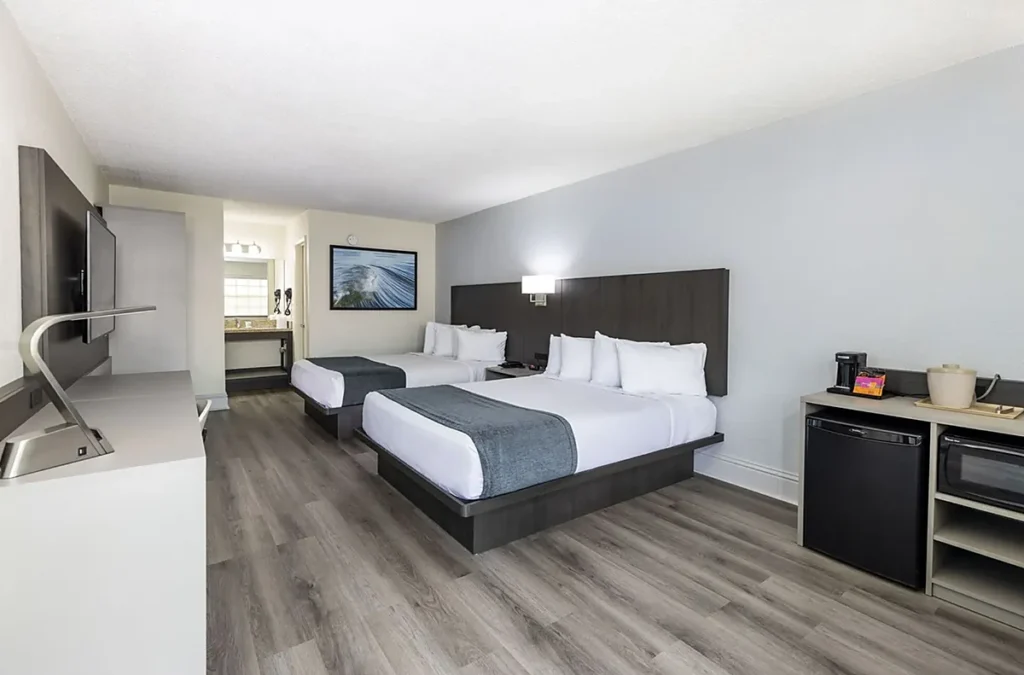 Quarto com duas camas, TV e comodidades práticas para famílias e grupos hospedados no Avanti International Resort em Orlando.