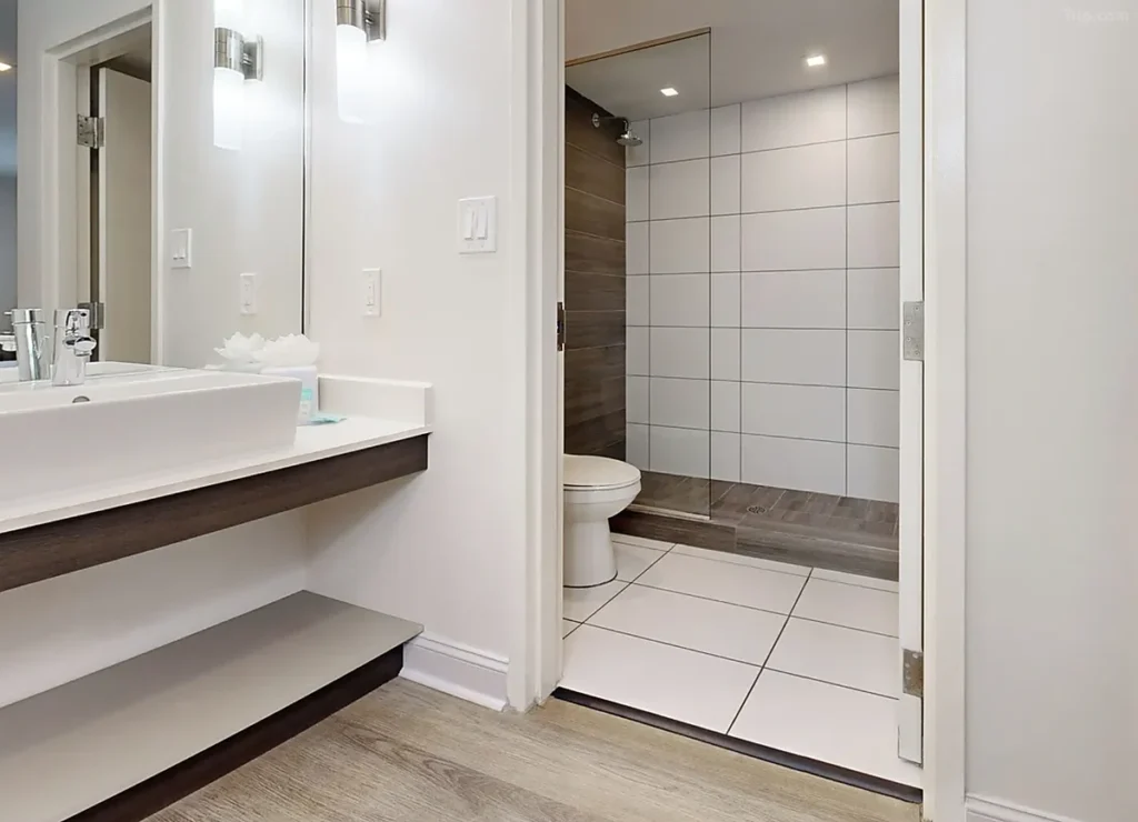 Banheiro de acomodação do Avanti International Resort, com design contemporâneo, bancada e chuveiro com box de vidro.